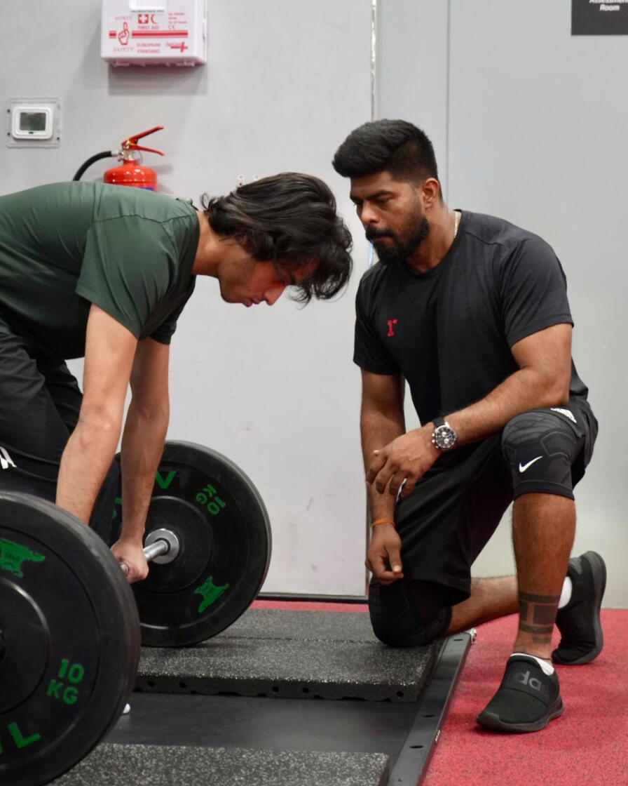 Sagar Jadhav coaching a client through a barbell deadlift setup